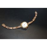 AN ANTIQUE 9CT GOLD WRISTWATCH ON 9CT GOLD EXPANDABLE STRAP A/F