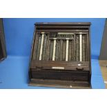 A VINTAGE OPTICIANS CABINET WITH ROLLER SHUTTER FRONT AND DRAWERS BELOW CONTAINING A QUANTITY OF