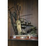 A LARGE SCULPTURE OF A GROUP OF OTTERS ON A WOODEN PLINTH