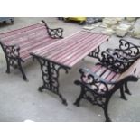 A CAST IRON AND WOODEN GARDEN SET COMPRISING A TABLE, TWO CHAIRS AND A BENCH