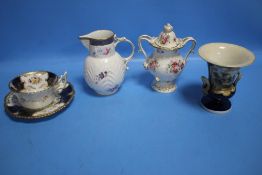 A COALPORT LIDDED VASE, A COALPORT CREAM JUG, CUP AND SAUCER AND AN UNNAMED VASE WITH HAND PAINTED