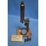A VINTAGE BRASS MICROSCOPE WITH ASSORTED SLIDES AND ADDITIONAL LENSES