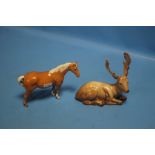 A BESWICK PALOMINO HORSE TOGETHER WITH A BESWICK RECUMBENT STAG
