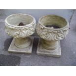 A PAIR OF CONCRETE PLANTERS AND PLINTHS