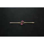 A 9CT GOLD BAR BROOCH SET WITH TWO PINK STONES