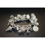 A HALLMARKED SILVER CHARM BRACELET APPROX WEIGHT - 87G