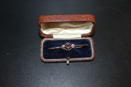 A VICTORIAN 9CT GOLD BAR BROOCH SET WITH A PINK STONE IN FITTED BOX