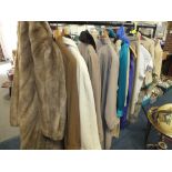 A RAIL OF LADIES CLOTHING TO INCLUDE A FAUX FUR COAT