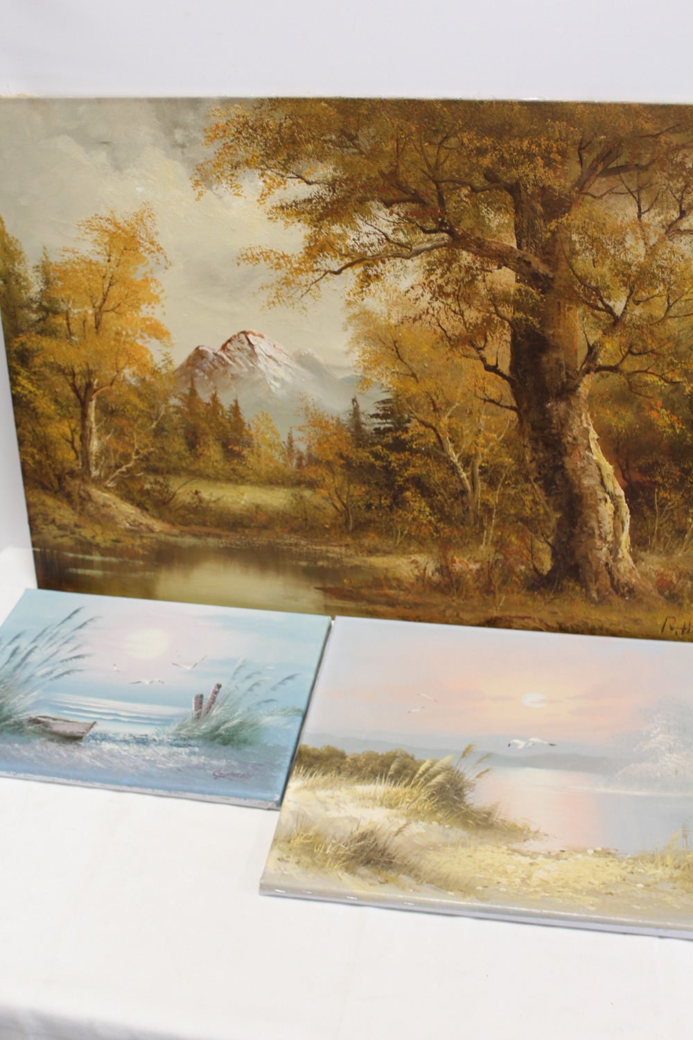 THREE UNFRAMED OIL ON CANVASES TO INCLUDE A WOODED MOUNTAINOUS LAKE SCENE