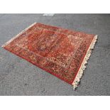 A LARGE EASTERN WOOLLEN RUG APPROX 200 X 138 CM A/F *10 CM TEAR TO ONE EDGE*