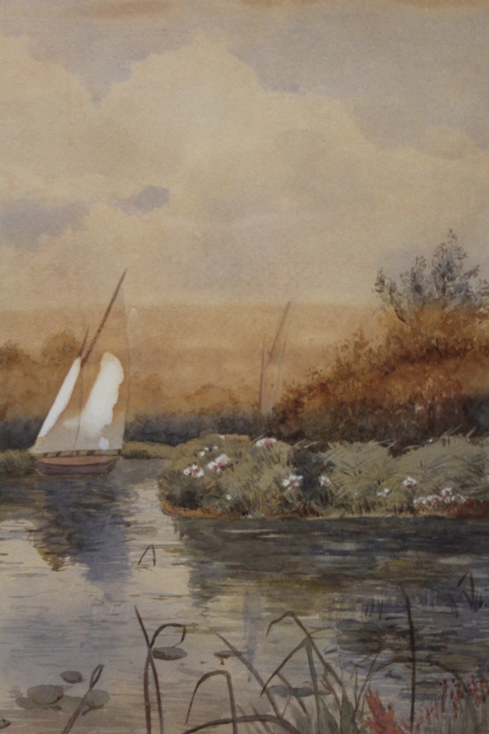 A GILT FRAMED AND GLAZED WATERCOLOUR OF A COUNTRY RIVER SCENE WITH SAIL BOAT 40CM X 28CM