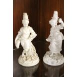 A PAIR OF ANTIQUE CERAMIC FIGURAL CANDLESTICKS WITH CROSSED SWORD STYLE BLUE BACKSTAMPS -SLIGHT