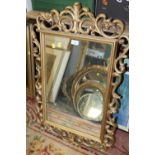 A REPRODUCTION GILT PIERCED FRAMED WALL MIRROR OVERALL SIZE - 90CM X 57CM