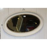 A CREAM PAINTED OVAL WALL MIRROR OVERALL SIZE - 84CM X 54CM