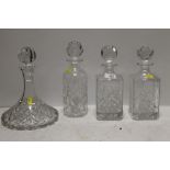 FOUR ASSORTED CUT GLASS DECANTERS TO INCLUDE A WATERFORD CRYSTAL EXAMPLE AND A SHIPS DECANTER
