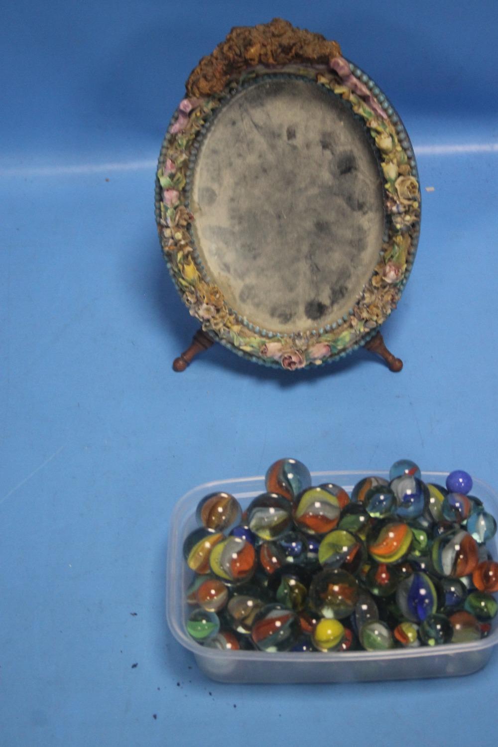 A SMALL DECORATIVE MIRROR TOGETHER WITH A QUANTITY OF MARBLES