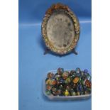 A SMALL DECORATIVE MIRROR TOGETHER WITH A QUANTITY OF MARBLES