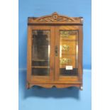 AN EDWARDIAN OAK SMOKERS CABINET FITTED WITH THREE DRAWERS