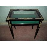 A GLASS EBONISED DISPLAY TABLE