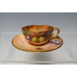 A ROYAL WORCESTER HAND PAINTED MINIATURE CUP AND SAUCER, slight damage to handle