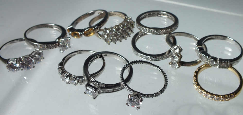 A COLLECTION OF TWELVE SILVER AND CZ DRESS RINGS, mostly QVC Diamonique examples. various designs