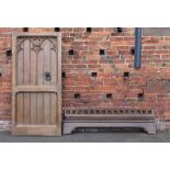 A LARGE OAK GOTHIC DOOR WITH ASSOCIATED RAIL, both with ecclesiastical carved detail, the door