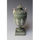 A SMALL CLASSICAL WEDGWOOD GREEN JASPERWARE TWIN HANDLED URN AND COVER, decorated in relief,