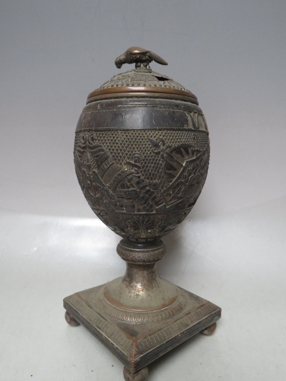 A 19TH CENTURY CARVED COCONUT SHELL AND LID, raised on a white metal covered support, H 23 cm, - Image 2 of 10