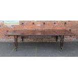 A LARGE VICTORIAN MAHOGANY WIND-OUT DINING TABLE WITH THREE ADDITIONAL LEAVES, raised on fluted