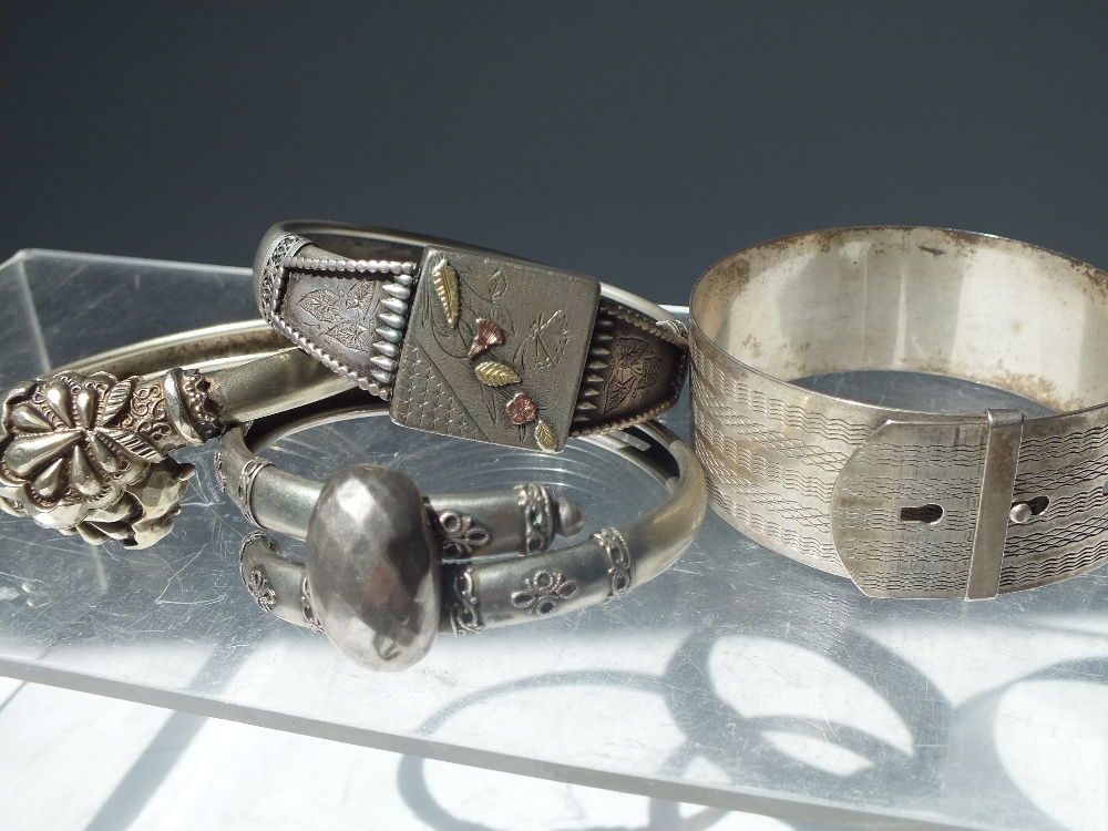 FOUR ASSORTED VINTAGE / ANTIQUE WHITE METAL BANGLES