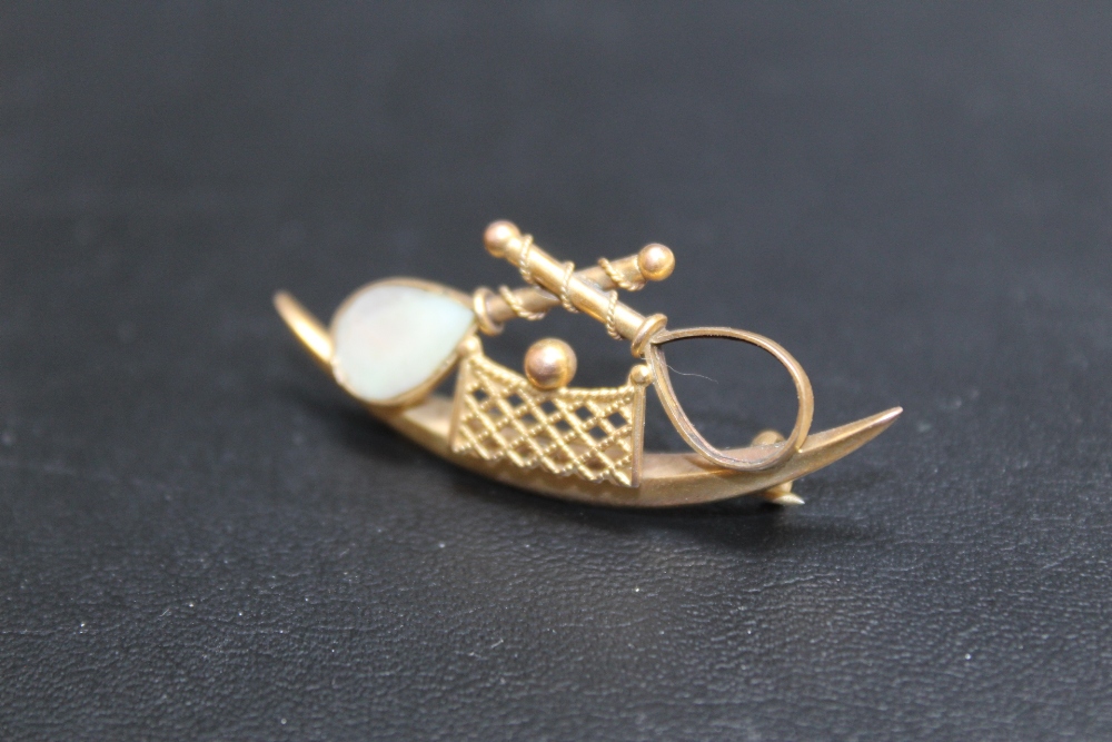 A NOVELTY 9CT GOLD TENNIS THEMED BROOCH, one racket missing its mother of pearl inlay, approx weight