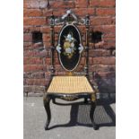 A VICTORIAN EBONISED BERGERE CHAIR WITH MOTHER OF PEARL FLORAL DETAIL, further painted gilt