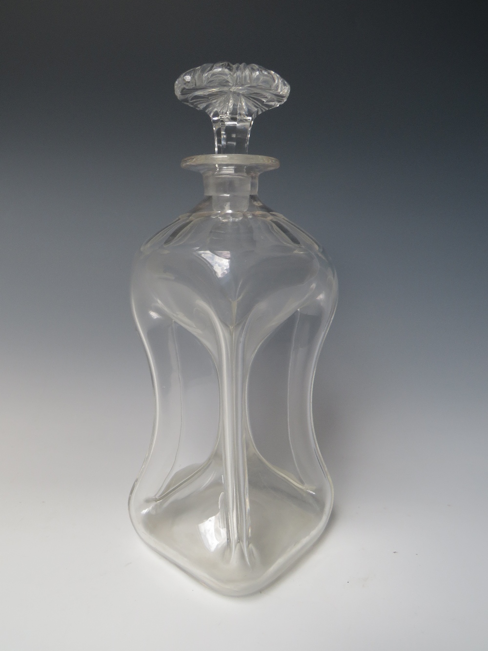 AN ANTIQUE CLEAR GLASS 'GLUG GLUG' DECANTER, with stopper, faceted embellishment to shoulders,