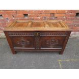 A 19TH CENTURY CARVED OAK TWO PANEL COFFER, raised on stile supports, H 58, W 110 cm