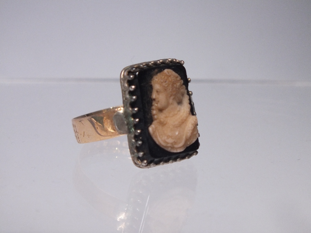 AN ANTIQUE GOLD PORTRAIT / CAMEO STYLE RING STAMPED '18' TO BAND, the black onyx type panel with