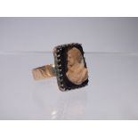 AN ANTIQUE GOLD PORTRAIT / CAMEO STYLE RING STAMPED '18' TO BAND, the black onyx type panel with