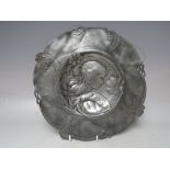 AN ART NOUVEAU CIRCULAR PEWTER DISH FOR RESTORATION- POSSIBLY WMF, embossed with a female head in