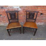 A PAIR OF ANTIQUE WOODEN CHAIRS, each having a carved depiction of a crowned man to the back, raised