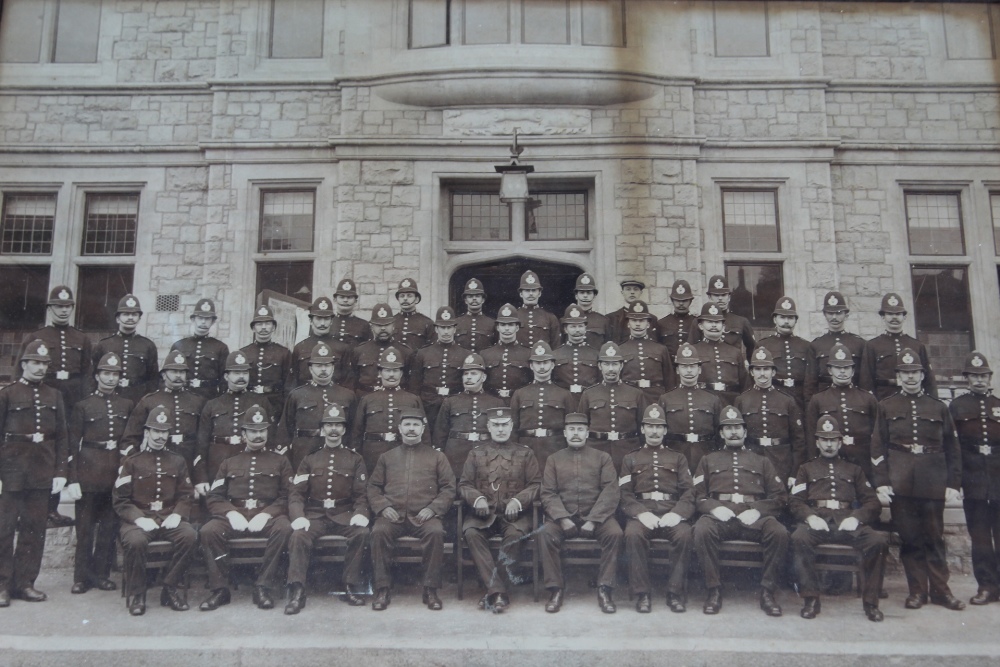 AN OAK FRAMED PRINT OF A POLICE SQUAD