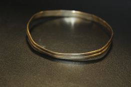 A HALLMARKED 9 CARAT GOLD BANGLE - MISSHAPEN APPROX WEIGHT - 9.7G