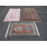 THREE EASTERN WOOLLEN RUGS MAINLY ON A PINK GROUND LARGEST 182 X 1`18 CM (3)