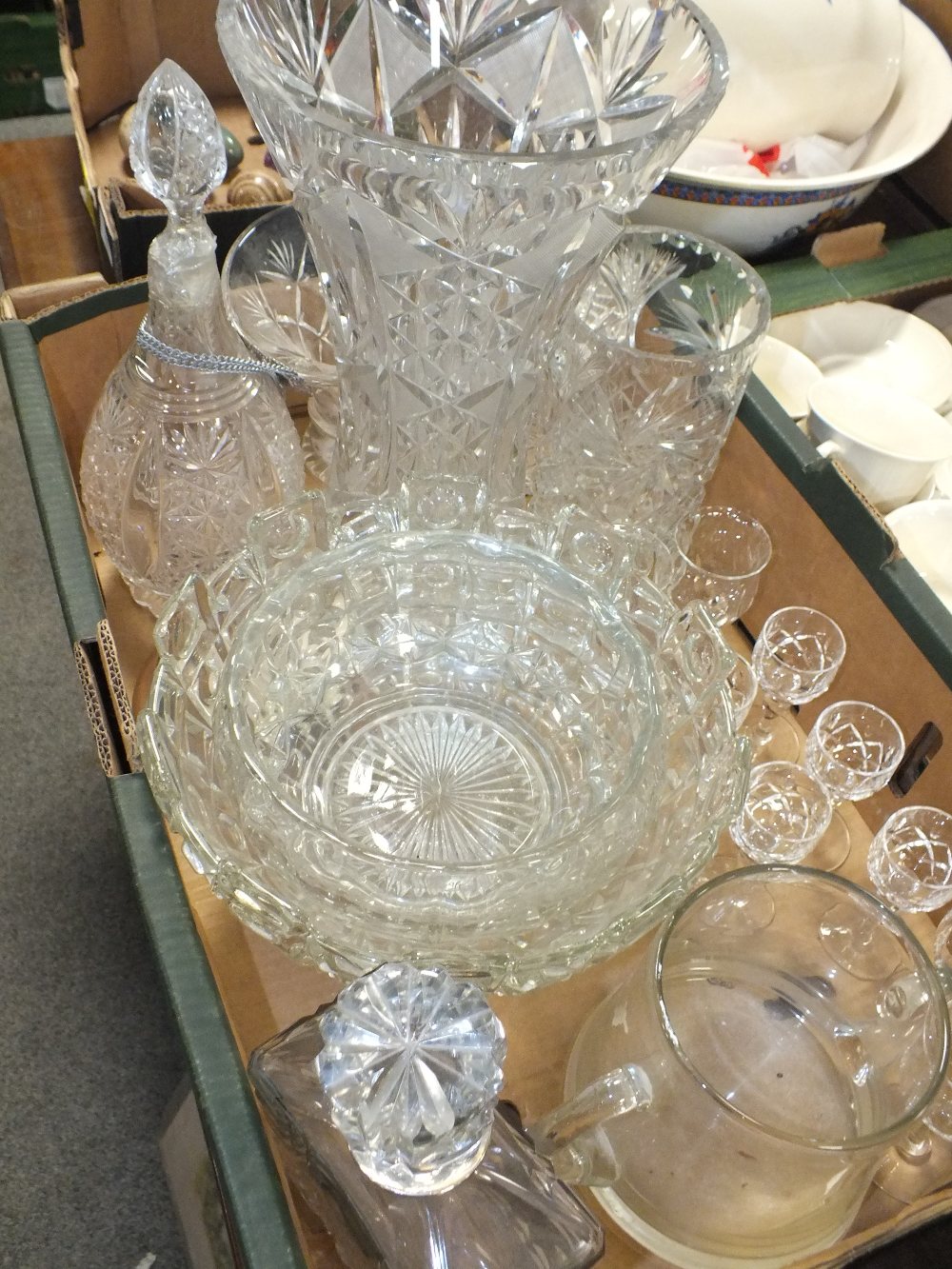A TRAY OF MOSTLY CUT GLASSWARE TO INCLUDE A LARGE VASE, WHITE METAL COLLARED DECANTER, DRINKING