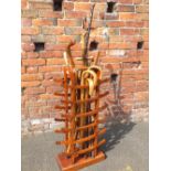 A LARGE WOODEN WALKING STICK STAND AND CONTENTS - H 92 CM