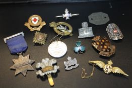 A COLLECTION OF MILITARY AND OTHER BADGES AND COLLECTORS ITEMS TO INCLUDE A YELLOW METAL RAF