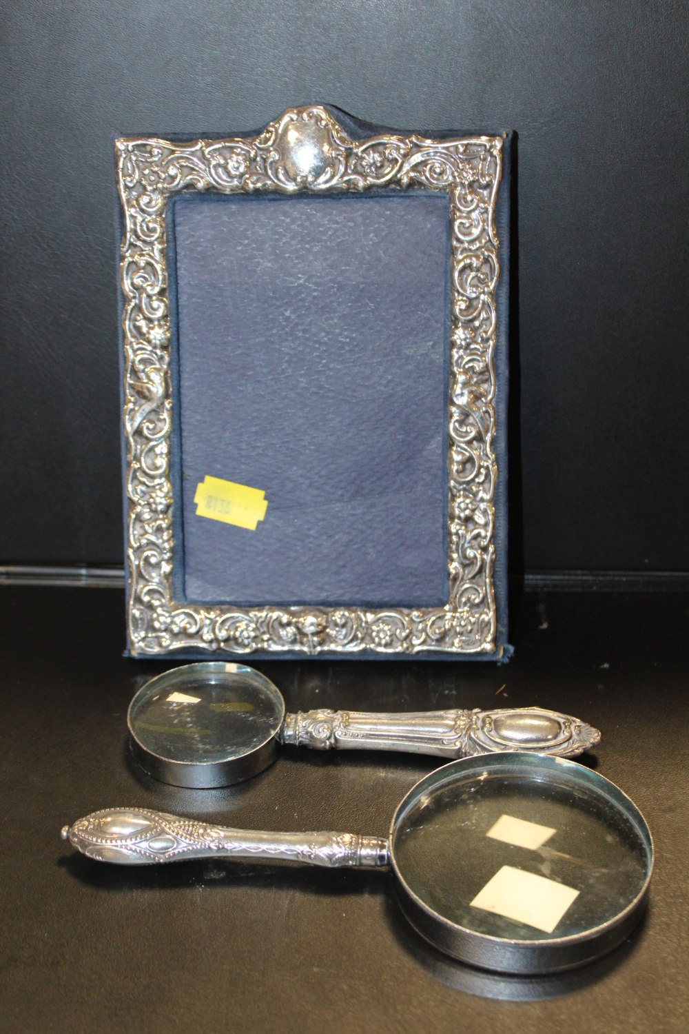 A HALLMARKED SILVER PICTURE FRAME TOGETHER WITH TWO SILVER HANDLED MAGNIFYING GLASSES