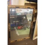 A GILT FRAMED MIRROR 74 X 104 CM