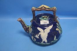 A 19TH CENTURY MAJOLICA TEAPOT DECORATED WITH A WHITE BIRD AND BULL RUSHES