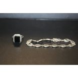 A STERLING SILVER BLACK ONYX AND MARCASITE DRESS RING TOGETHER WITH A SILVER BRACELET