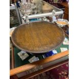 AN EDWARDIAN TURNED OAK LAZY SUSAN, THE TOP WITH MOULDED RIM AND BASE AND SPREADING FOOT