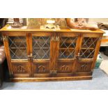 A 'WEBBER' OAK LEADED LOW BOOKCASE WITH CARVED DETAIL, W 140 CM